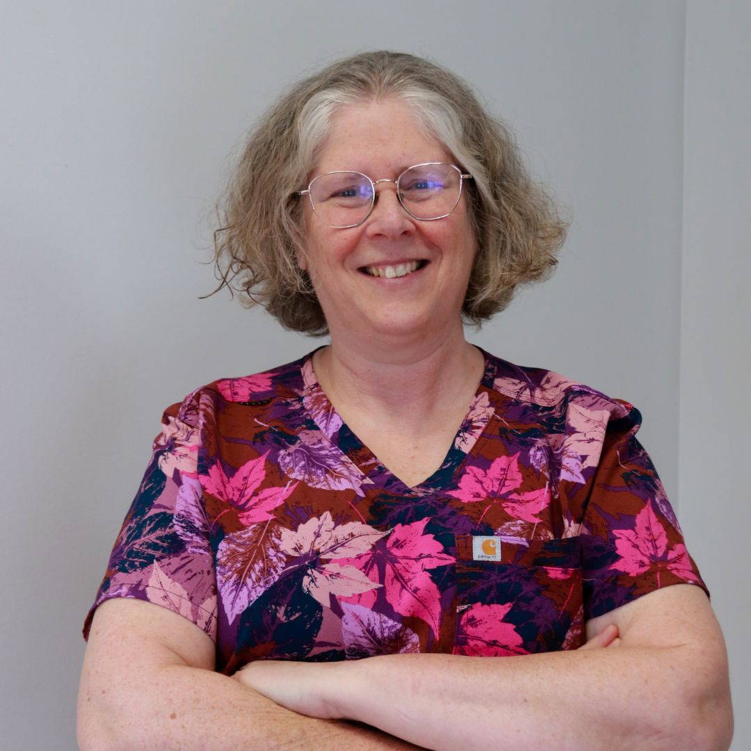 a person with glasses standing in front of a white wall a person with glasses standing in front of a white wall
